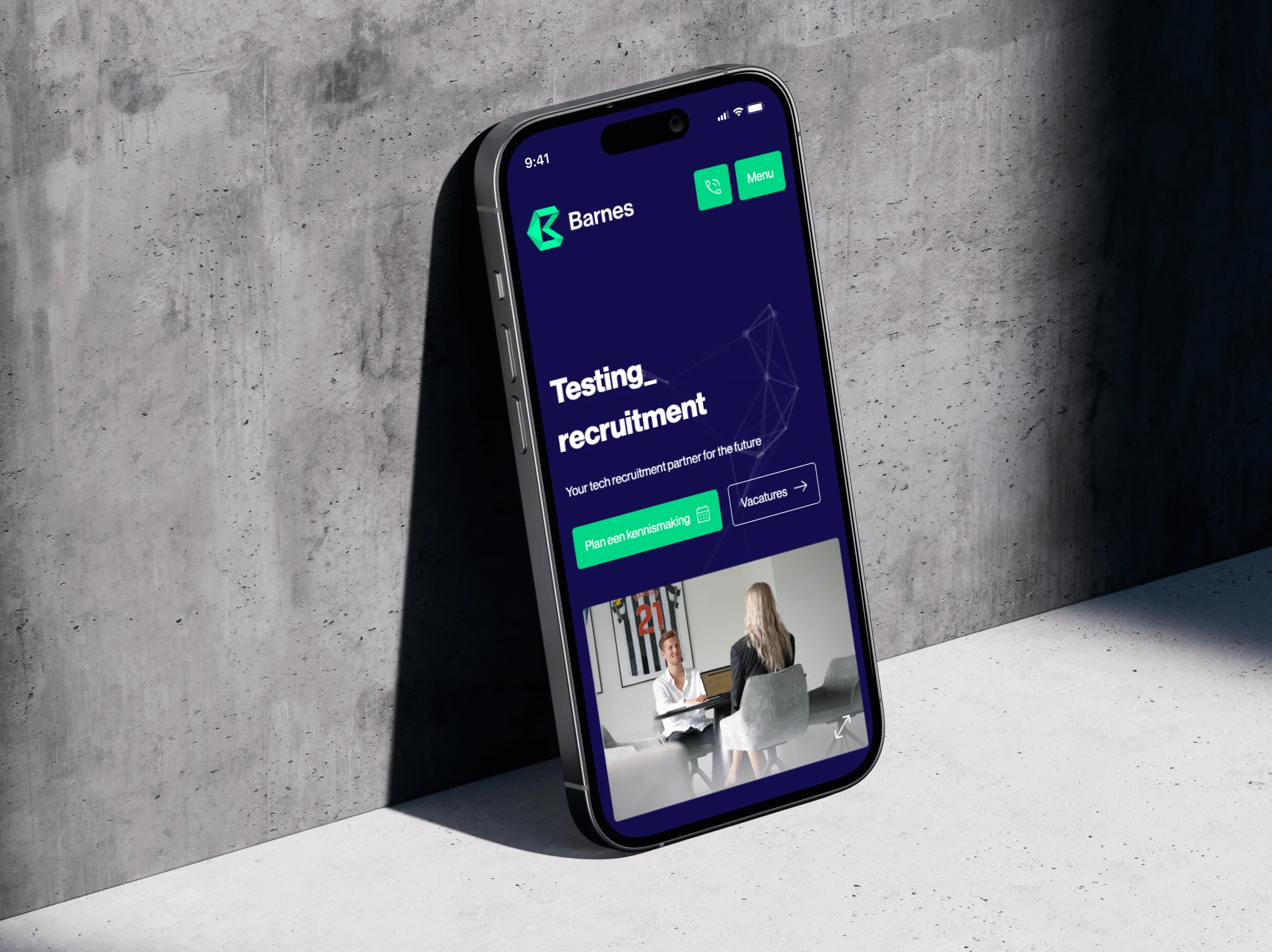 Smartphone met een donkerblauwe webpagina van Barnes gericht op technologie werving tegen betonnen achtergrond