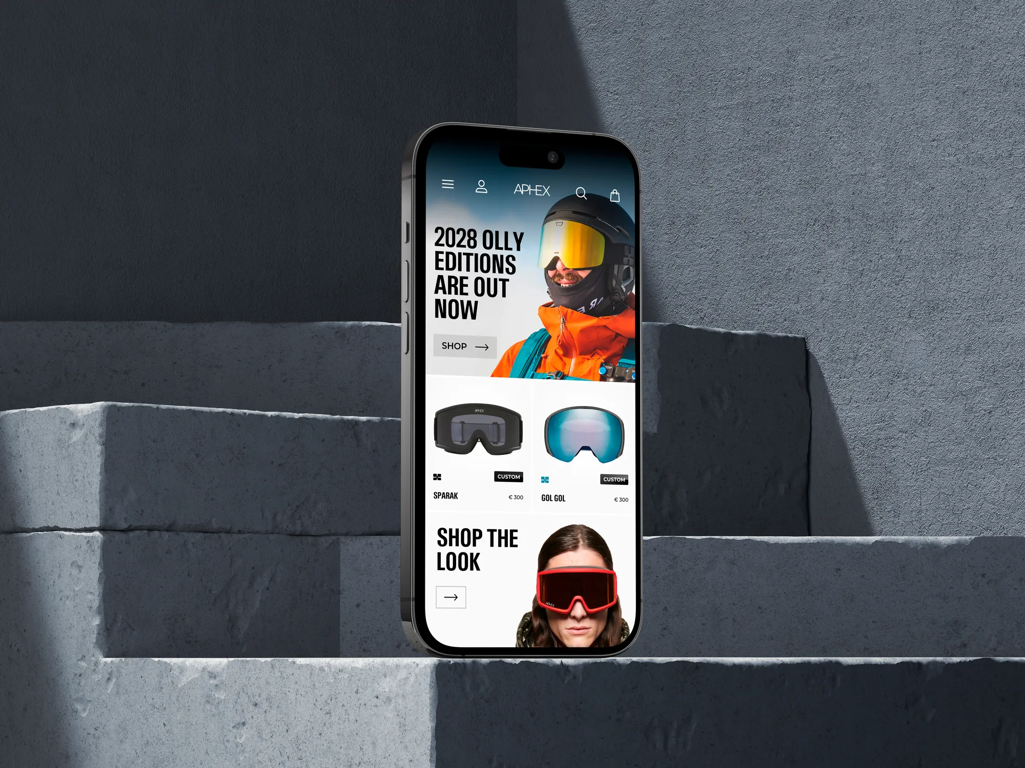 Smartphone op betonnen trap met winkelwebsite sportaccessoires, skigoggles en prijzen zichtbaar