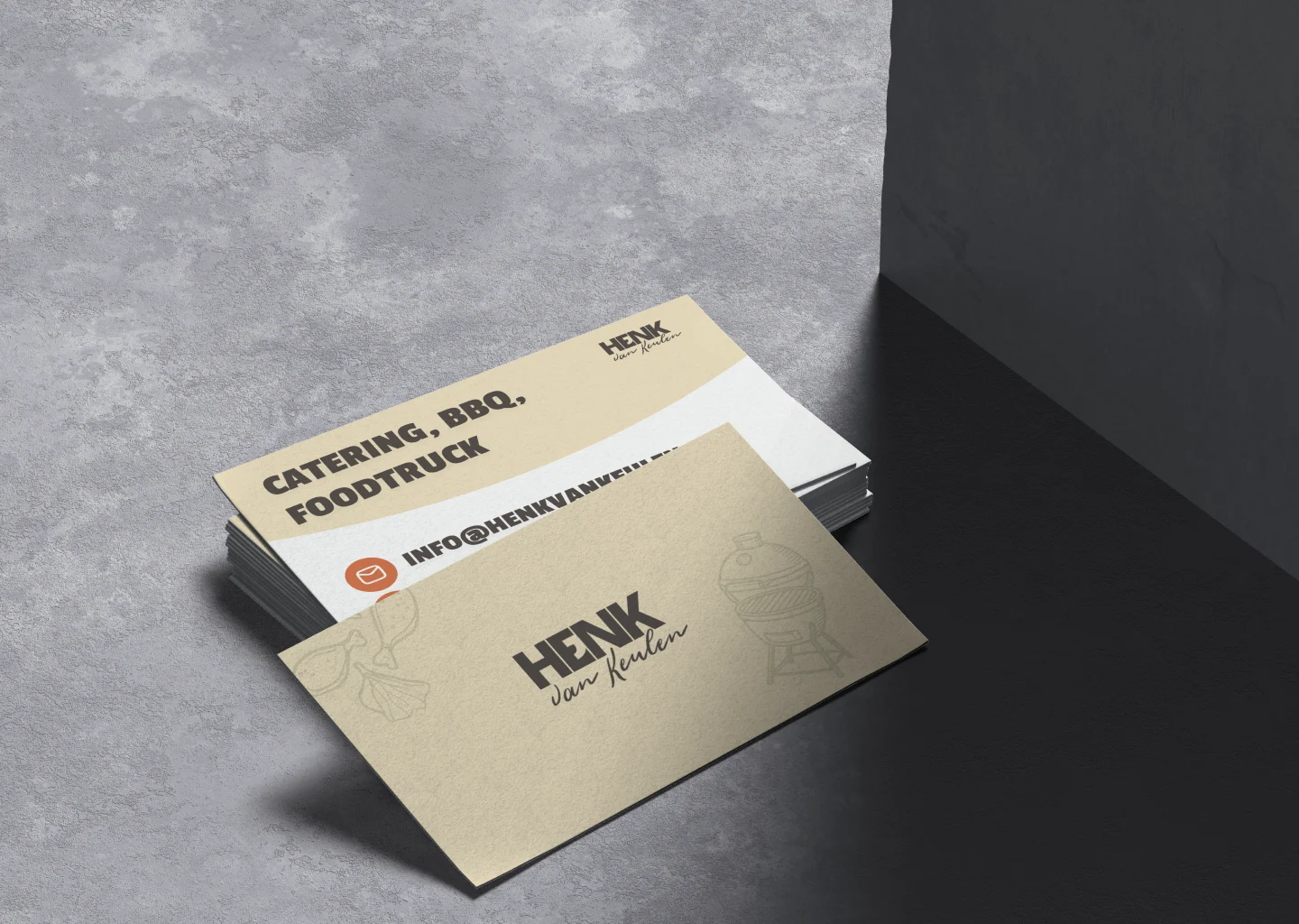 Stapels visitekaartjes op grijze ondergrond, goudkleurig kaartje met tekst HENK van Keulen en illustratie barbecue